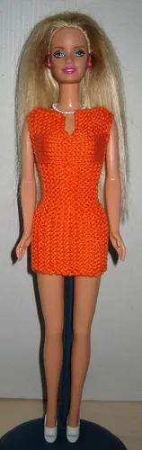 Barbie i orange stickad klänning med hålmönster.