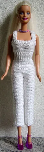 Barbie i vit stickad byxdress med hålmönster.