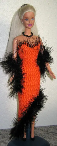 Barbie i orange stickad klänning med svart luddkant.