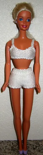 Barbie i vit stickad topp och shorts med hålmönster.