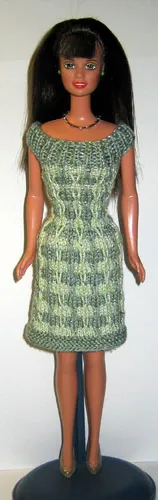 Barbie i grön stickad klänning med vitt geometriskt mönster