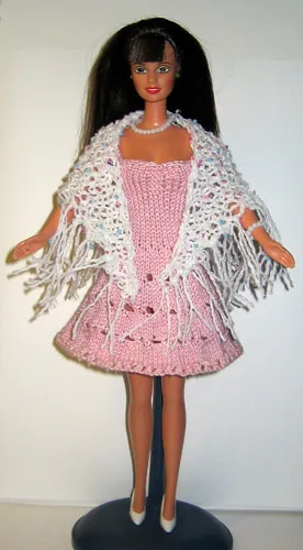 Barbie i rosa klänning med vit stickad sjal med pärlor och fransar.