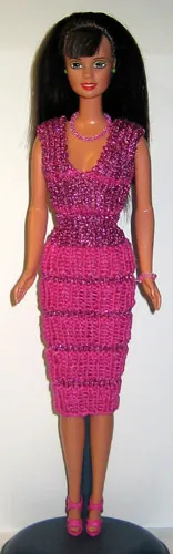 Barbie i cerise stickad klänning med glitterränder.