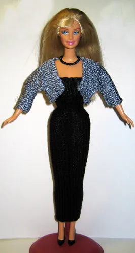 Barbie i kort blå glitterjacka över svart klänning.