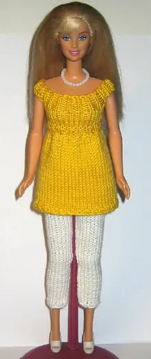 Barbie i gul stickad tunika med vita leggings.
