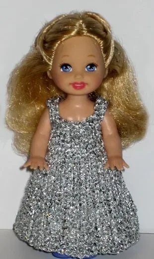 Barbie i glittrande silverklänning med hålmönster.