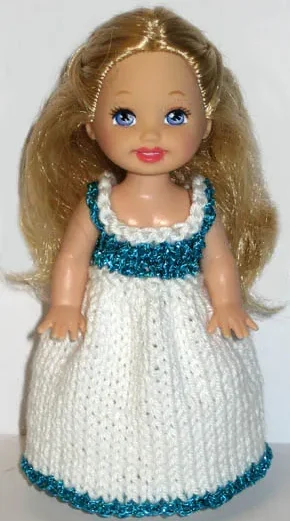Barbie i vit stickad klänning med turkosa kanter och detaljer.