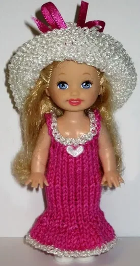 Barbie i cerise klänning med vit kant och glittrig vit hatt.