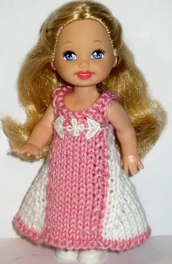 Barbie i stickad vit och rosa klänning med hålmönster.