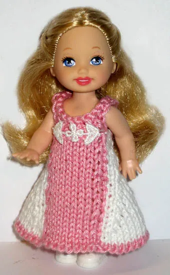 Barbie i stickad vit och rosa klänning med hålmönster.