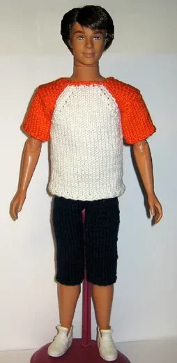Barbie i stickad vit tröja med orange raglanärmar.