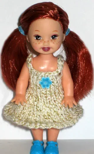 Barbie-docka i guldig glitterklänning med blå detaljer och matchande skor.