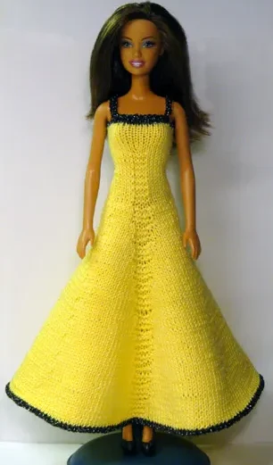 Barbie i gul stickad långklänning med svart kant.