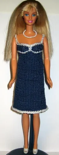 Barbie i blå stickad klänning med vita spetskanter och axelband.
