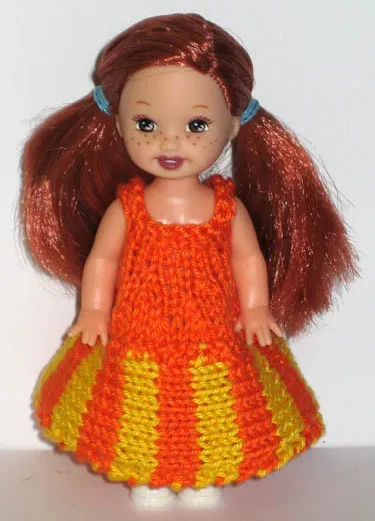 Barbie-docka i orange och gul randig stickad klänning.