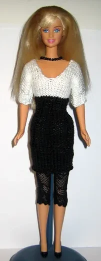 Barbie i stickad klänning med svart kjol och vit topp med korta ärmar.