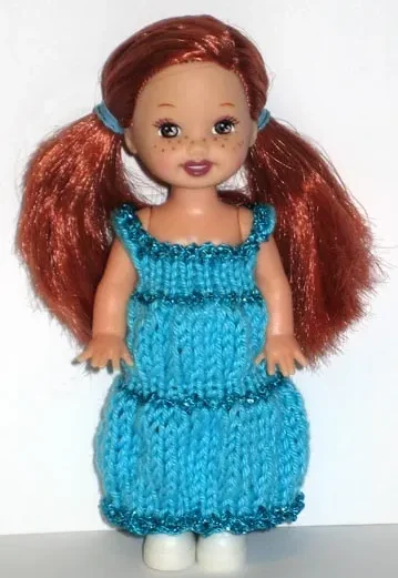 Barbie-docka i turkos stickad klänning med glitterband.