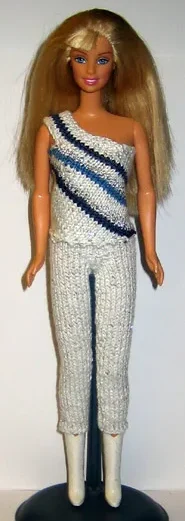 Barbie i vit topp med blå ränder och beige byxor.