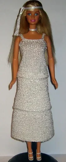 Barbie i vit glitterklänning med smala axelband och långt pannband.