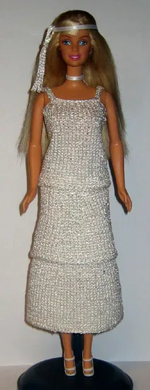 Barbie i vit glitterklänning med smala axelband och långt pannband.