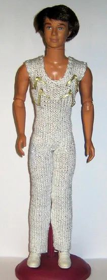 Ken-docka i vit glittrig jumpsuit med djup urringning.