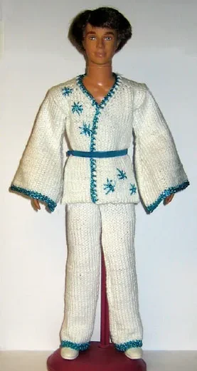Barbie i vit stickad jacka och byxor med turkosa broderade detaljer.