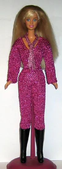 Barbie i lila glittrig jumpsuit med djup v-ringning och svarta stövlar.