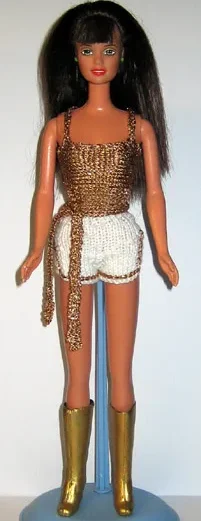 Barbie i guldglittrig topp, vita shorts och höga guldstövlar.