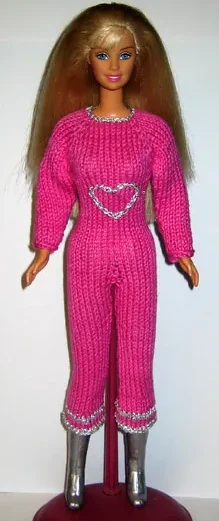 Barbie i rosa stickad jumpsuit med silverdetaljer och hjärtmotiv.