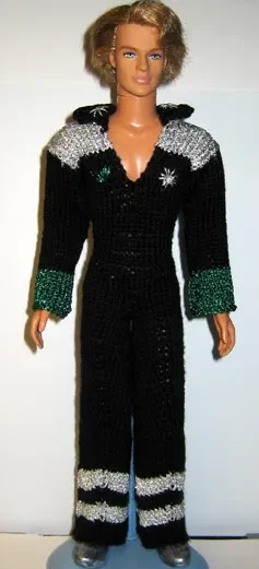 Barbie i svart stickad jumpsuit med silver- och gröna glitterdetaljer.
