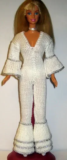 Barbie i vit stickad byxdress med vida ben och silvervolanger.