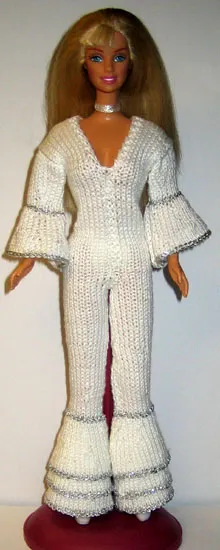 Barbie i vit stickad byxdress med vida ben och silvervolanger.