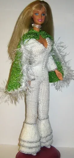 Barbie i vit jumpsuit med grön stickad cape med vit pälskant