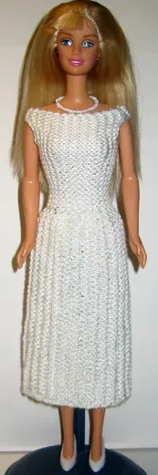 Barbie i vit glittrig ärmlös klänning.