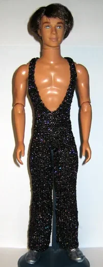 Ken i svart glittrig jumpsuit med djup v-ringning.