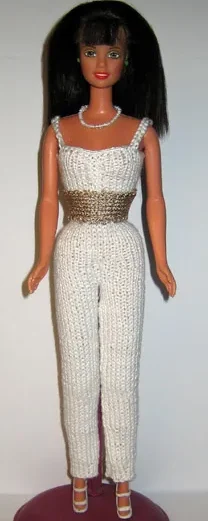 Barbie i vit stickad jumpsuit med guldskärp.