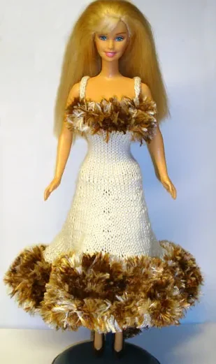 Barbie i beige stickad klänning med brun luddkant.