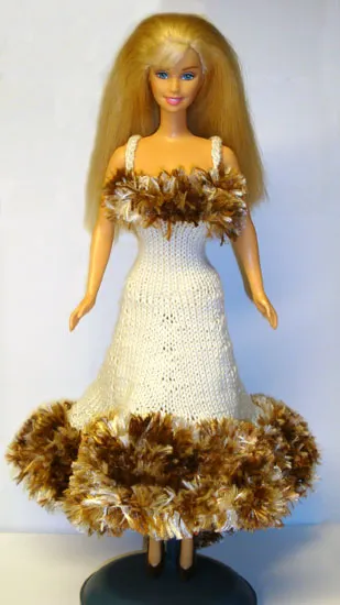 Barbie i beige stickad klänning med brun luddkant.