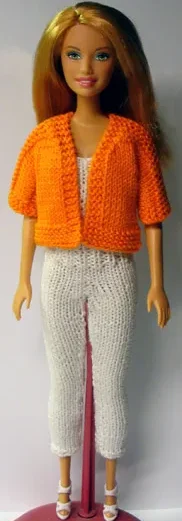 Barbie i orange stickad jacka med vita byxor.