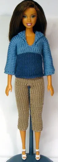 Barbie i ljusblå stickad tröja med v-ringning och beige capri-byxor.
