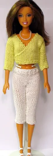 Barbie i ljusgrön stickad omlott-topp och vita capribyxor.