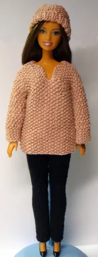 Barbie i rosabeige stickad tröja med matchande mössa och svarta byxor.