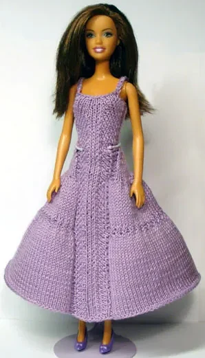 Barbie i lila stickad långklänning med flätmönster.