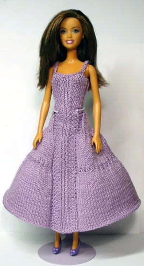 Barbie i lila stickad långklänning med flätmönster.