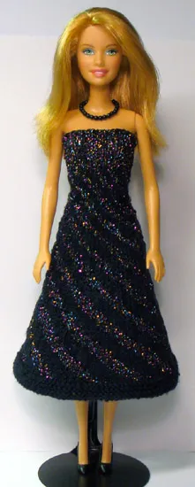 Barbie i svart klänning med glitterränder i diagonalt mönster.