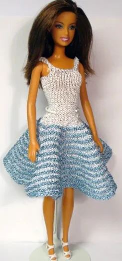 Barbie i vit stickad klänning med ljusblå randig kjol.
