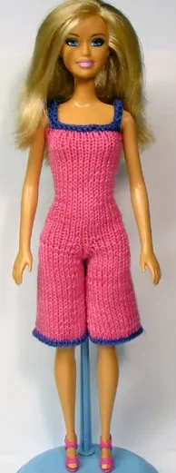 Barbie i cerise stickad byxdress med lila kantband och korta ben.