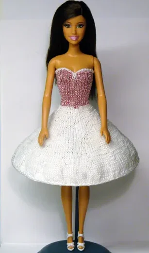 Barbie i rosa och vit stickad klänning med corsage och kort kjol.