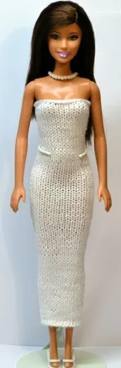 Barbie i vit paljetterad tubklänning med pärlhalsband.