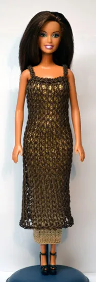 Barbie i brun stickad hålmönstrad tunika över beige underklänning.